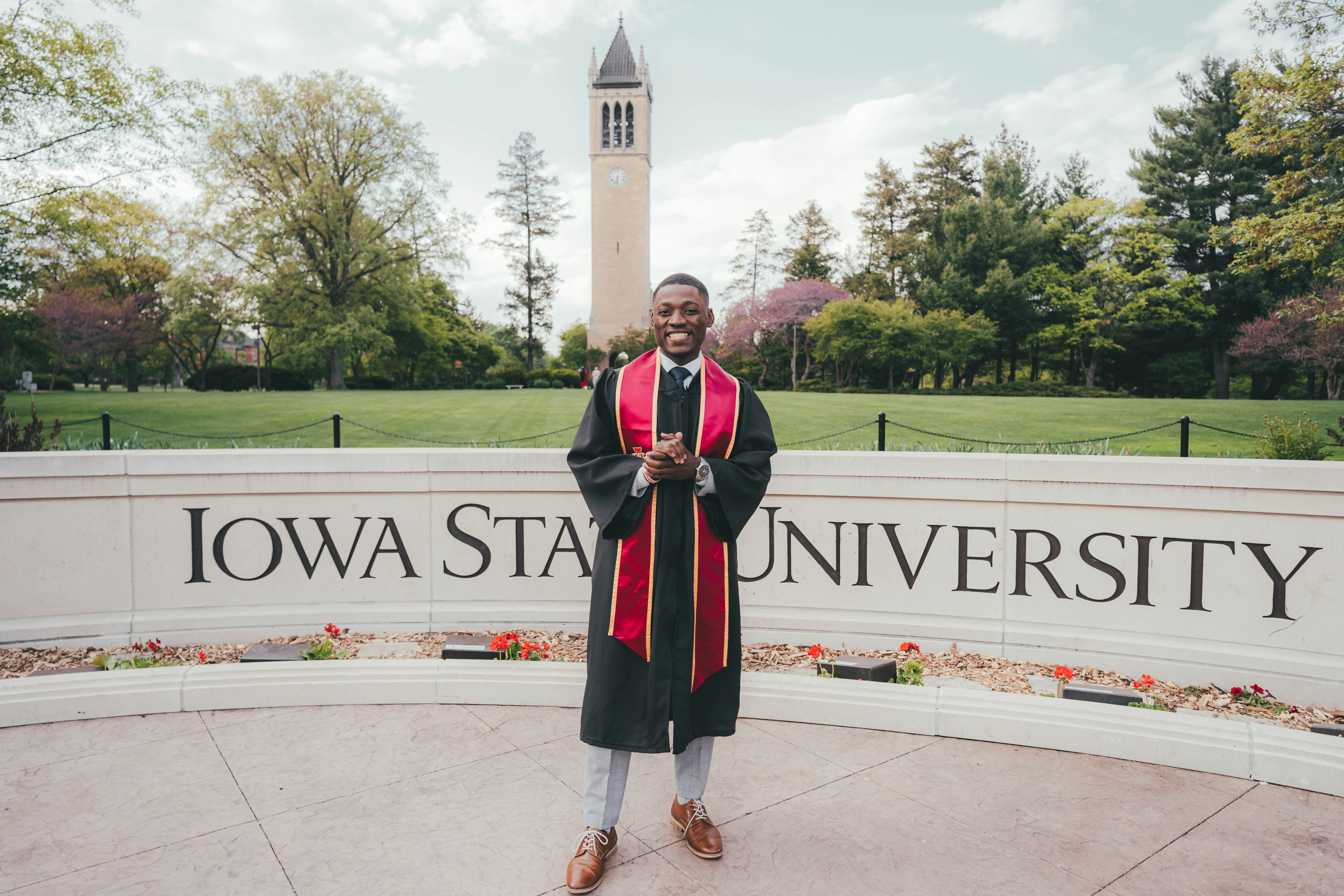 man in black and red academic dress standing on gray concrete floor during daytime